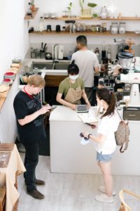 Four young adult employees in their coffeeshop workplace; highlighting how banks view employee income
