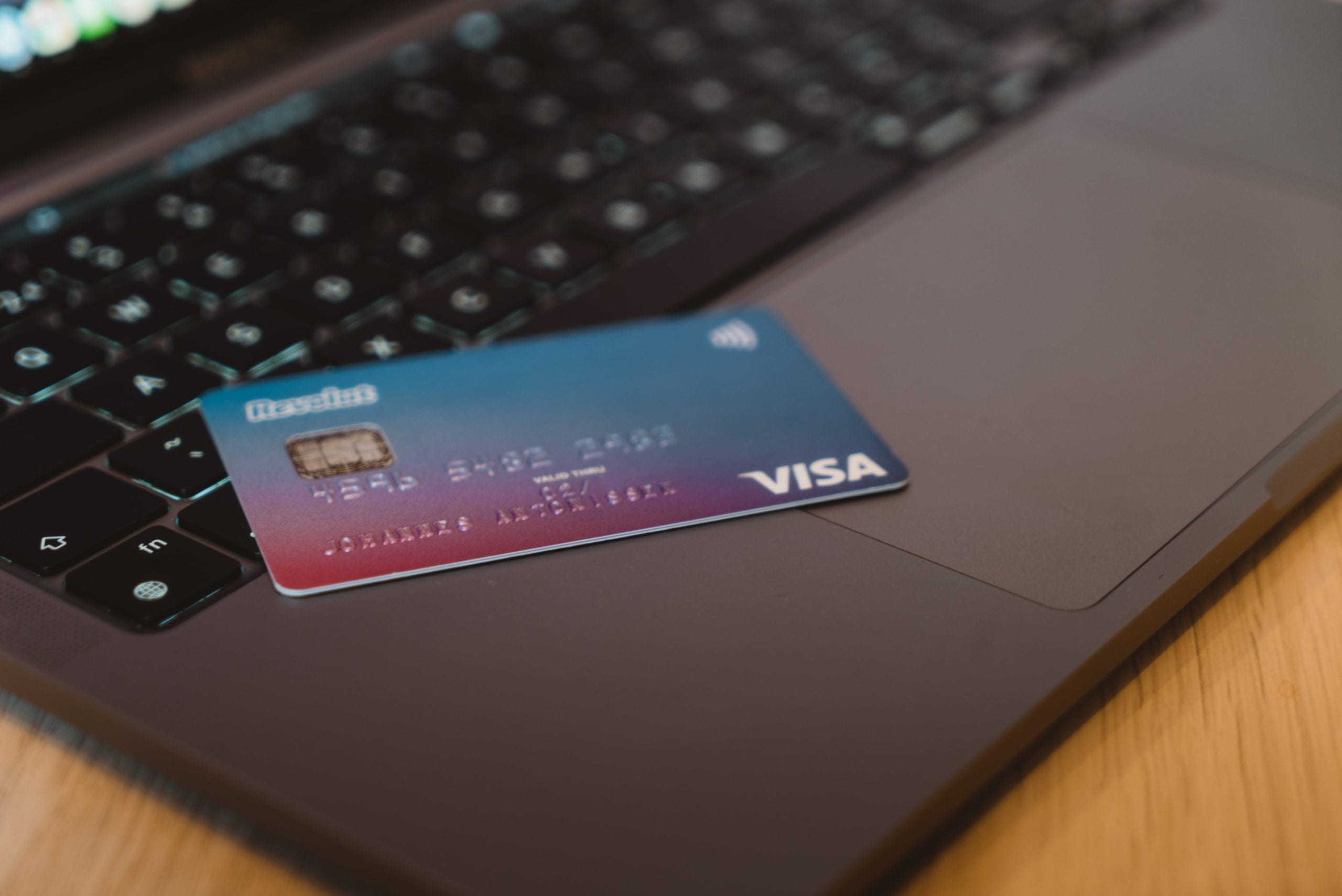 Closeup of visa credit card on laptop, in relation to acquiring credit