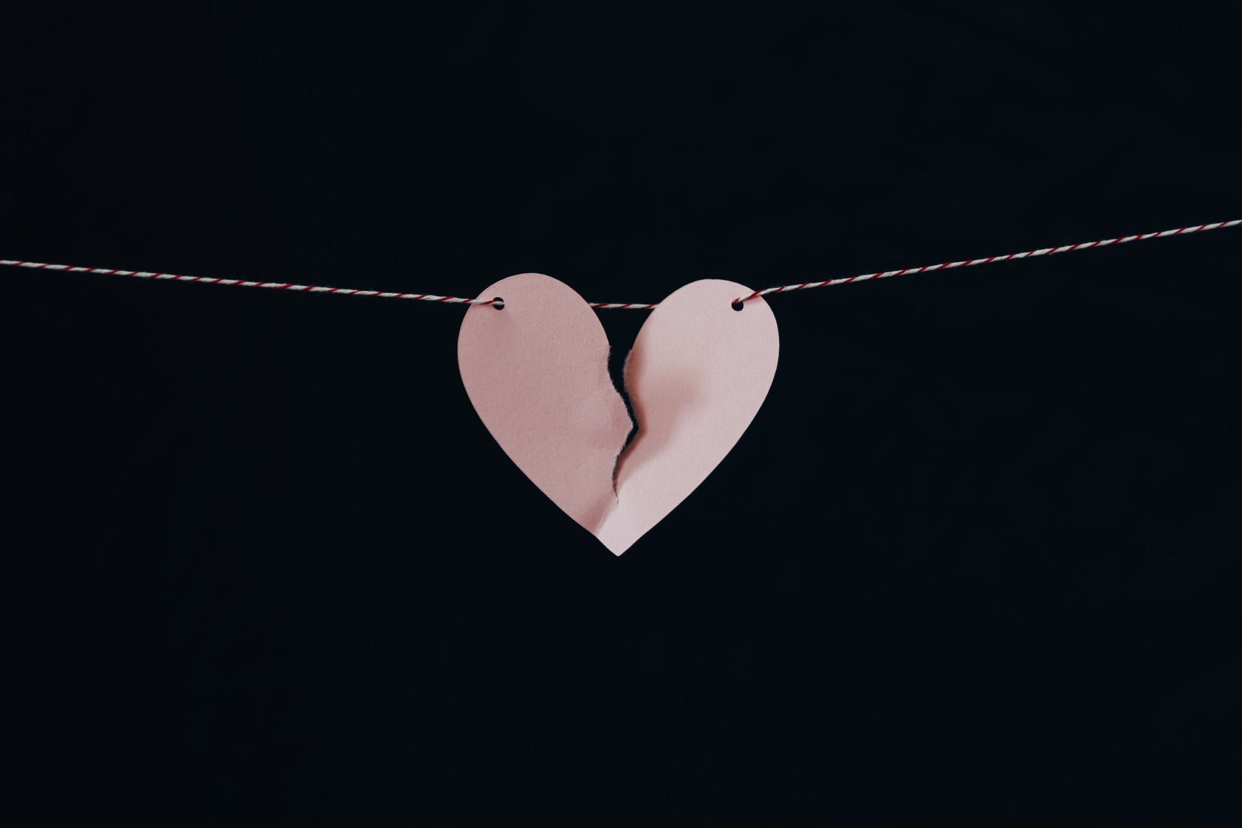 a pink paper heart on a string banner with a rip down the middle, highlighting the effect of separation or divorce on mortgages