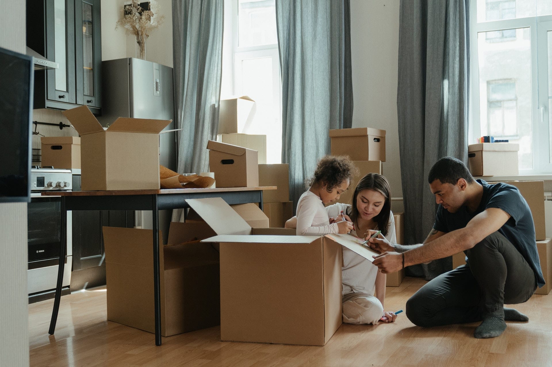 family surrounded by moving boxes, highlighting the importance of choosing the right mortgage broker