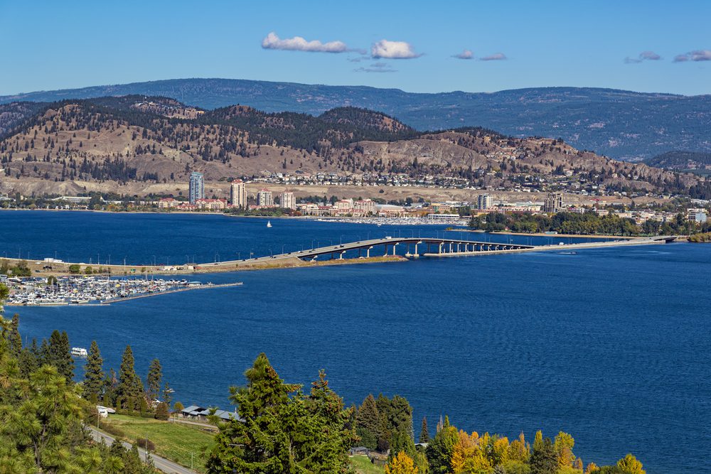 a photo from west kelowna overlooking downtown kelowna, knox mountain and the bridge