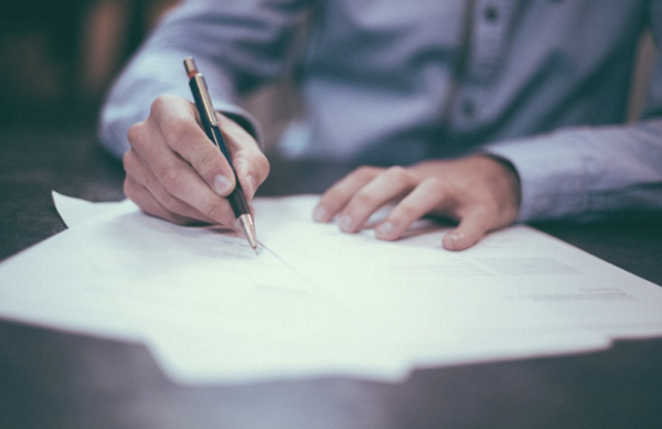 a hopeful homeowner signing for their first time closing costs.