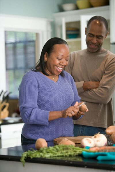 a photo of a mom and dad preparing dinner.