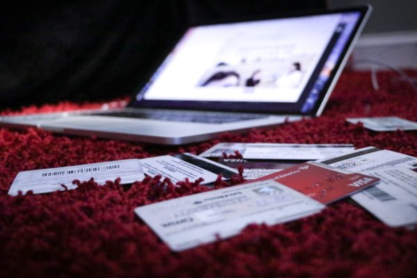 a laptop lying on a shag red rug with credit cards scattered around, highlighting credit score impact on mortgage