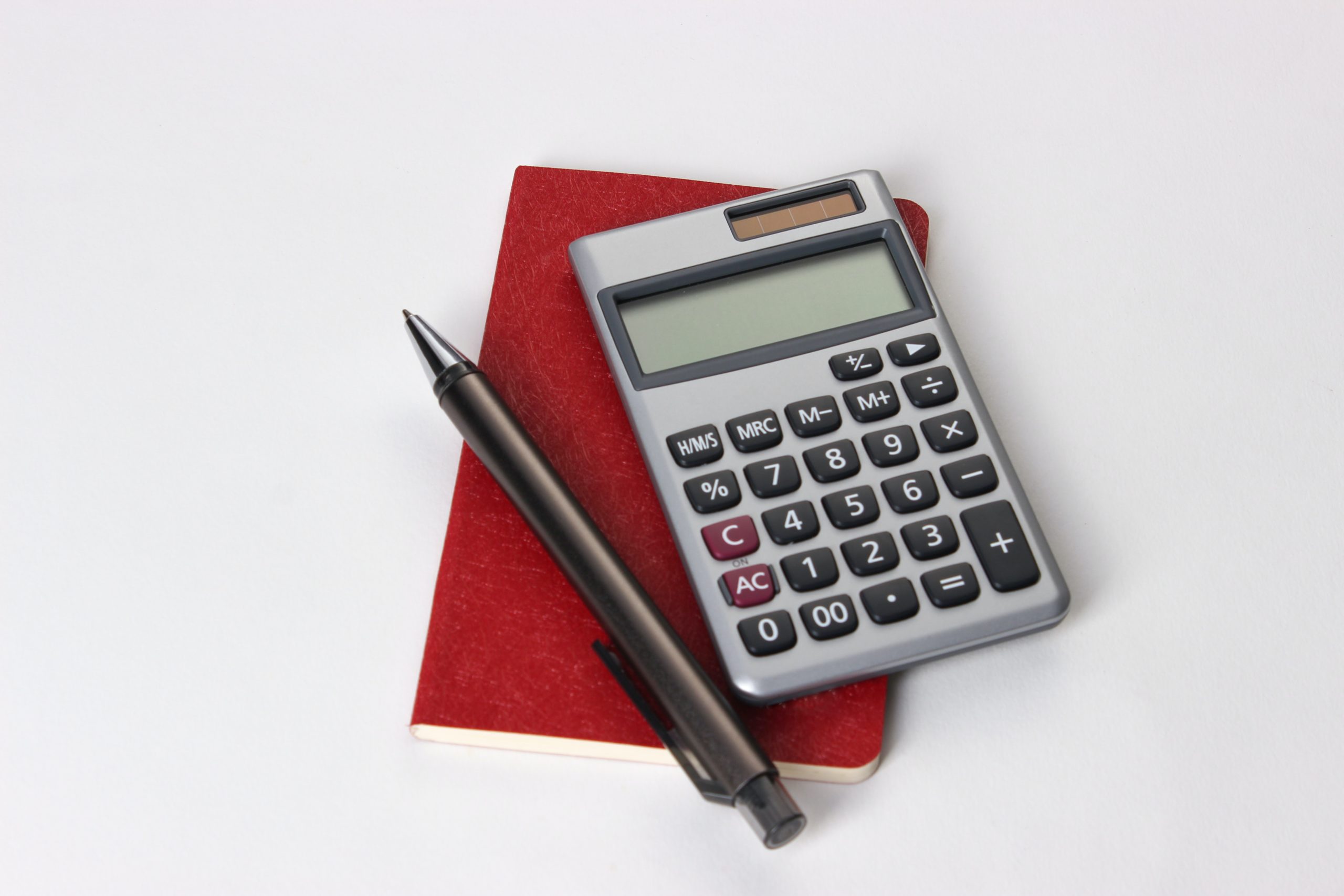a calculator, pencil and notebook on a desk surface, highlighting mortgage affordability in BC